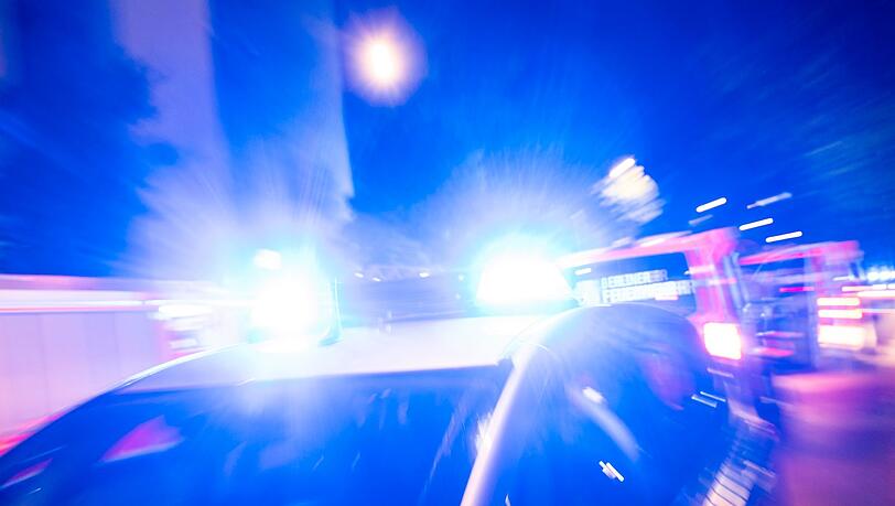 Ein Streifenwagen der Polizei steht mit Blaulicht an einem Einsatzort.