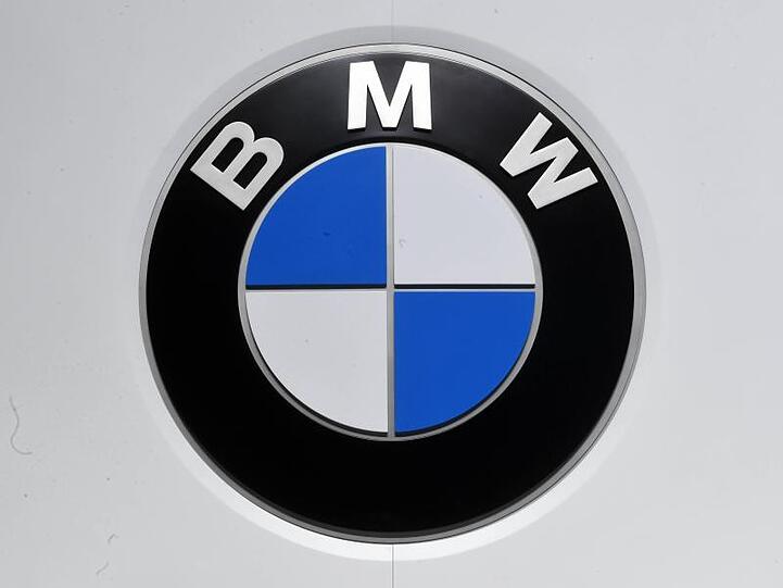 Ein BMW Logo ist von grauem Hintergrund umgeben. Foto: Uli Deck/dpa/Archivbild