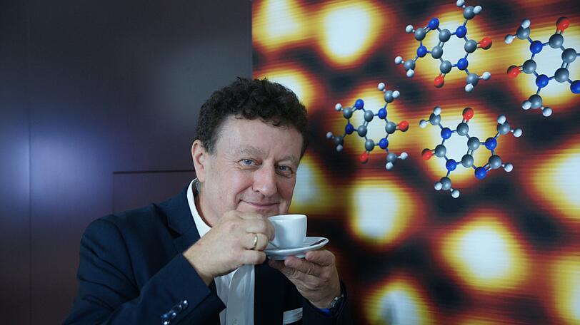 Dr. Wolfgang Heckl, Generaldirektor des Deutschen Museums vor einer Mikroskop-Darstellung von Kaffee.