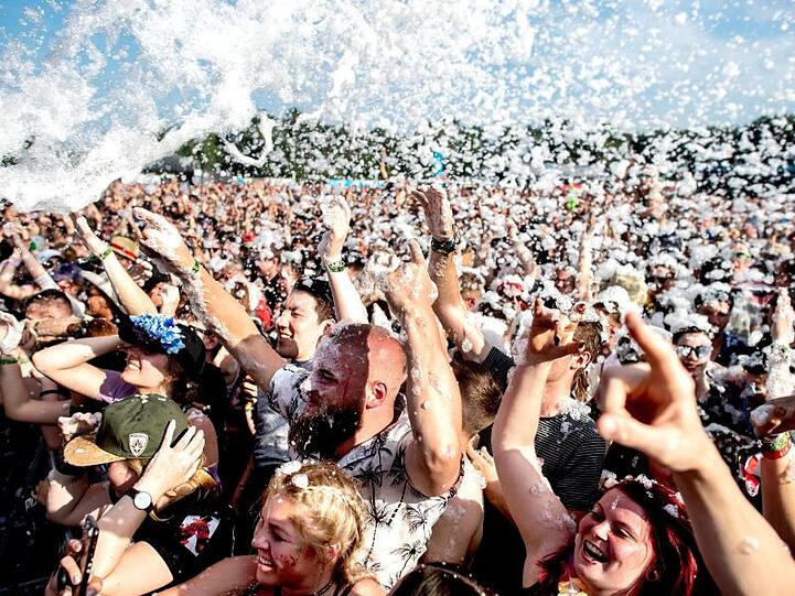 Besucher feiern auf dem Hurricane Festival während eines Konzerts in einem Schaumbad. Foto: Hauke-Christian Dittrich/dpa