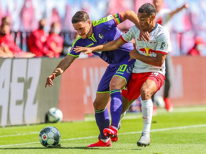 Der Freiburger Christian Günter (l) schirmt den Ball gegen Tyler Adams ab.