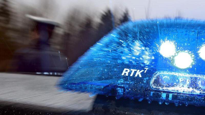 Ein Polizist steht neben einem Streifenwagen mit Blaulicht. Foto: Karl-Josef Hildenbrand/dpa/Symbolbild