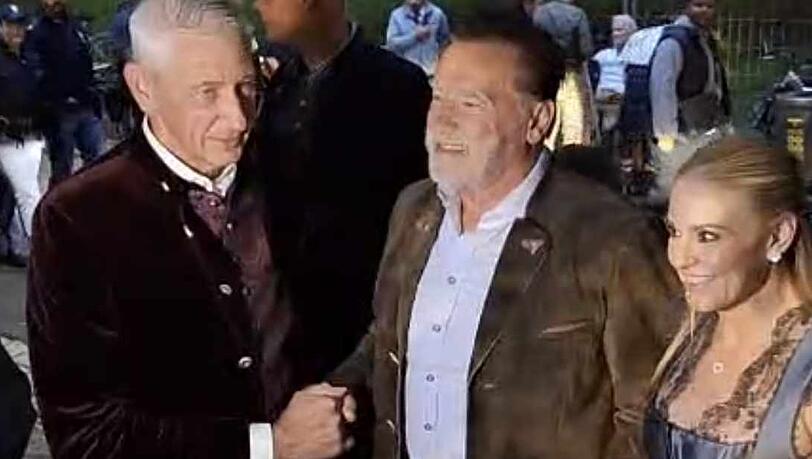 Arnold Schwarzenegger mit Freundin bei seiner Ankunft im Marstall-Festzelt. Wirt Siegfried Able freut sich über den Promi-Besuch.