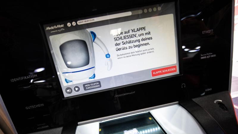 Ein Handy liegt in dem optischen Mechanismus eines "EcoATM" in einer MediaMarkt Filiale. Foto: Lino Mirgeler Ein Handy liegt in dem optischen Mechanismus eines "EcoATM" in einer MediaMarkt Filiale. Foto: Lino Mirgeler