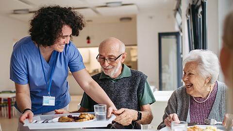 In einem Pflegeheim wird Bewohnern Mittagessen serviert. Viele Bundesl&auml;nder k&auml;men ihrer Aufgabe, etwa Kosten f&uuml;r Instandhaltung und Ausstattung von Pflegeeinrichtungen zu &uuml;bernehmen, "nur unzureichend nach", sagt der Pr&auml;sident des DRK, Hermann Gr&ouml;he.