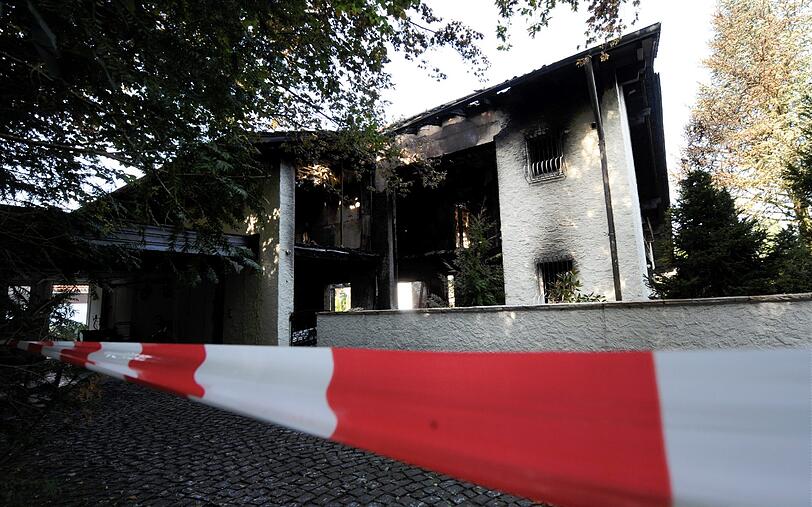 Blick auf die verkohlte Villa des Bayern-Stars Breno: Auch nach Tagen stehen noch Dienstfahrzeuge der Polizei vor dem Anwesen in Grünwald