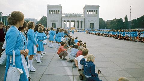 Hostessen und Kinder bilden ein Spalier auf dem Münchner Königsplatz im Rahmen der Eröffnungsfeierlichkeiten der Olympischen Spiele 1972. Diese Veranstaltung sollte die Stadt für immer verändern und bereichern.