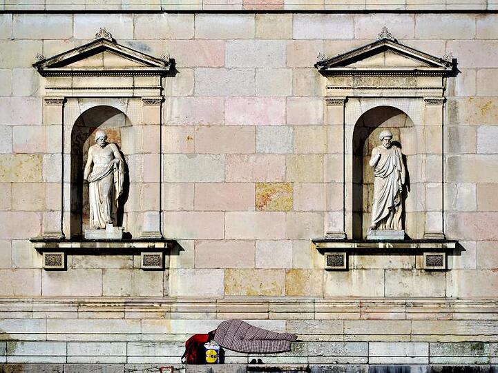 Ein Obdachloser Mann liegt vor der Glyptothek in München (Bayern). Foto: Nicolas Armer/Archiv