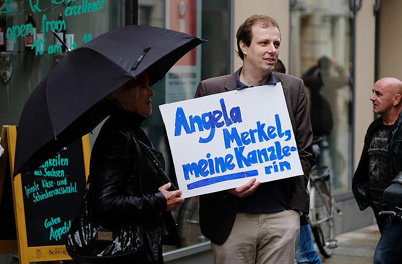 Doch es gibt auch Unterstützung für Angela Merkel: Ein Passant hält in Dresden ein Schild mit der Aufschrift "Angela Merkel, meine Kanzlerin" in der Hand.