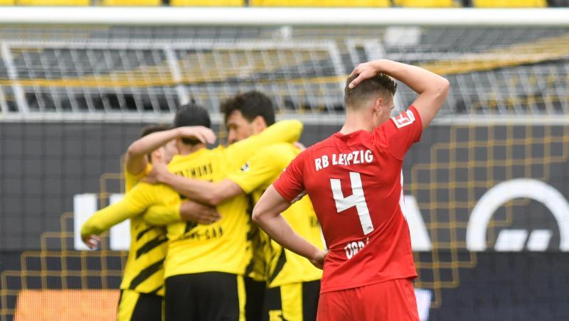 Leipzigs Abwehrspieler Willi Orban fasst sich nach der Niederlage beim BVB an den Kopf - im Hintergrund feiern die Dortmunder Spieler den Sieg.