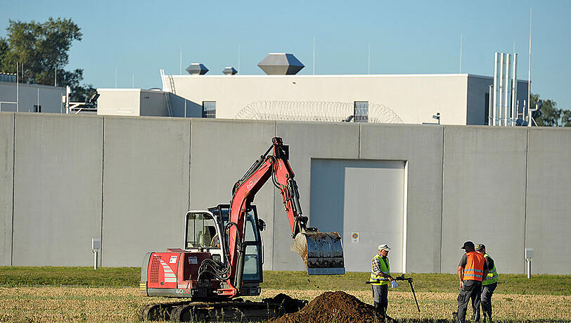 Vor dem Gefängnis heben Kampfmittelexperten den Bodden aus.
