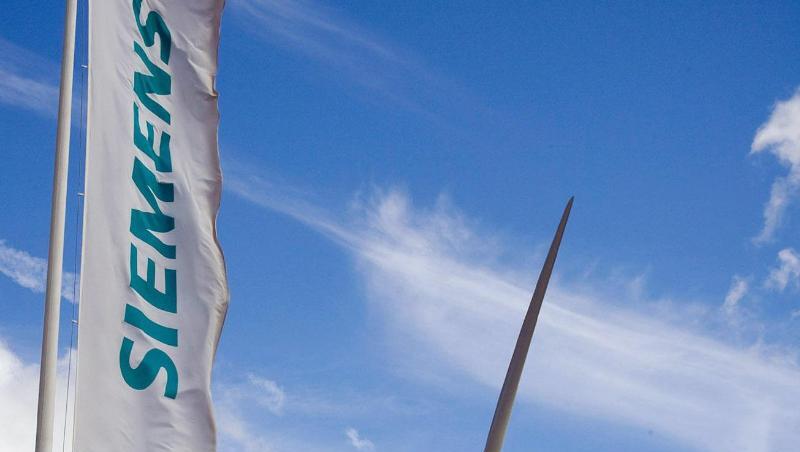 Eine Siemens-Fahne und eine Windkraftanlage sind zu sehen. Foto: Jürgen Winzeck/Siemens/dpa/Archivbild Eine Siemens-Fahne und eine Windkraftanlage sind zu sehen. Foto: Jürgen Winzeck/Siemens/dpa/Archivbild