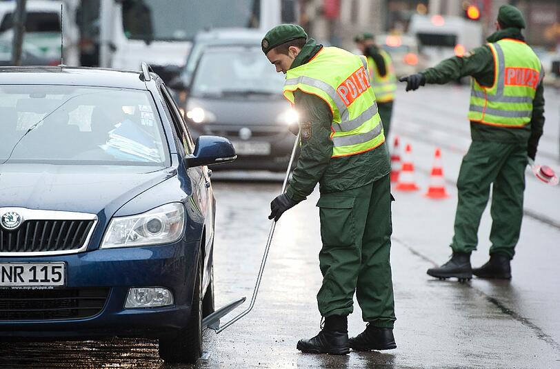 Sicherheitskonferenz in München: Ein Polizeibeamter kontrolliert vor Beginn der SiKo den Unterboden eines Fahrzeugs mit einem Spiegel.