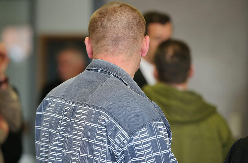Der wegen Mordes angeklagte Aleksandr M.(r) und der wegen schwerer Körperverletzung mitangeklagte Viktor H. (vorn) im Landgericht in Ansbach vor Prozessbeginn im Sitzungssaal. Aleksandr M. soll einen Obdachlosen mit Tritten getötet und danach auf ein Bahngleis gelegt haben, um die Tat zu vertuschen.