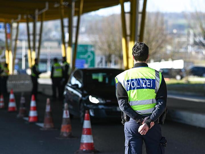 Deutsche Polizisten kontrollieren Einreisende an einem Grenzübergang.