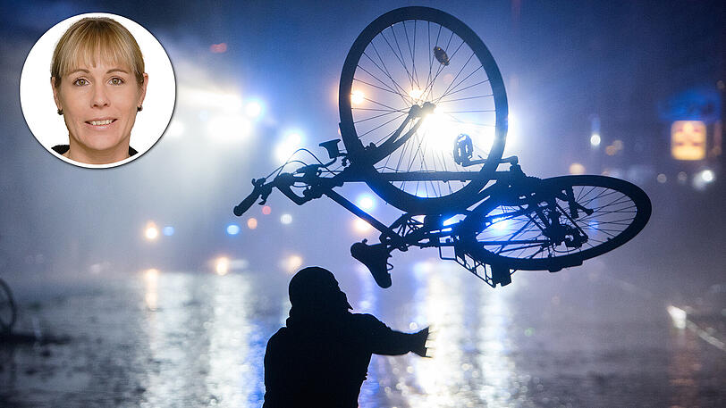 Ein Randalierer wirft in Hamburg im Schanzenviertel ein Fahrrad in Richtung von Wasserwerfern.