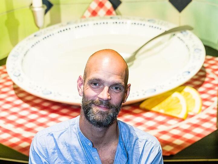 Der Schauspieler Tobias Kilian steht vor dem Bühnenbild des Ohnsorg-Theaters. Foto: Markus Scholz/Archivbild
