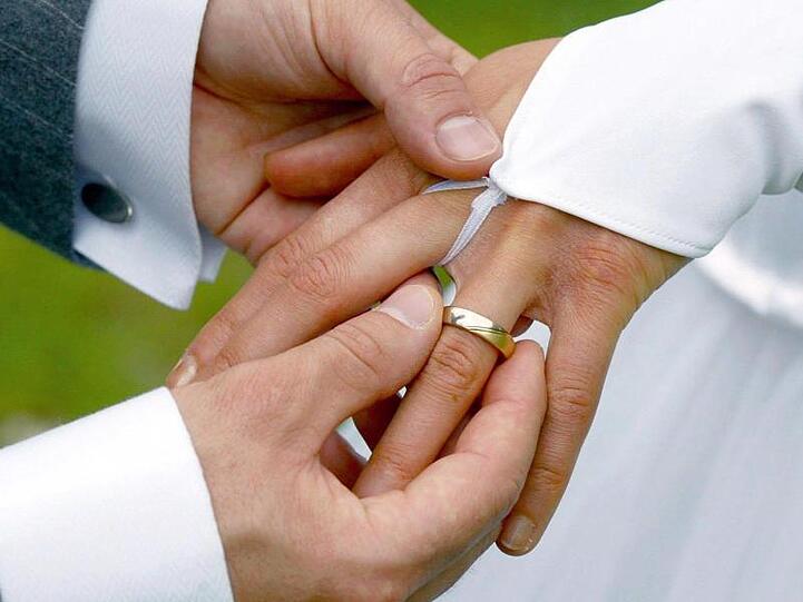 Ein Bräutigam streift bei der Trauung seiner Braut den Ehering über den Finger. Foto: Andreas Lander/zb/dpa/Symbolbild