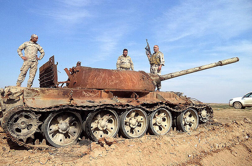 Irakische Soldaten stehen auf einem zerstörten Panzer nahe der Stadt Tikrit.