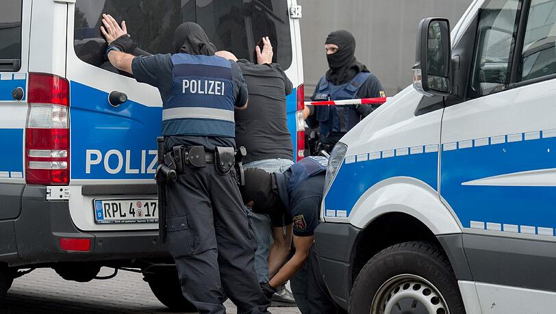 Polizisten durchsuchen auf dem Gelände des Flughafens Frankfurt einen Mann. Polizisten durchsuchen auf dem Gelände des Flughafens Frankfurt einen Mann.