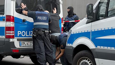 Polizisten durchsuchen auf dem Gelände des Flughafens Frankfurt einen Mann.