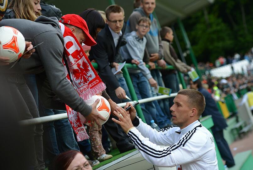 "Dankeschön, Polen" und "Gefällt mir" auf Polnisch - mit 11.000 Fans gerät das erste DFB-Training in Polen zum herzlichen Willkommensfest - und zur Geburtstagsparty für Lukas Podolski.