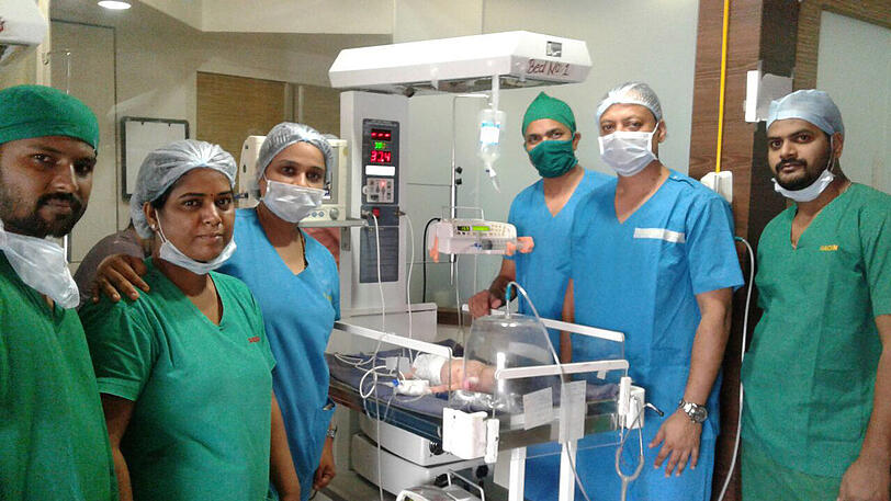 Das Ärzte-Team in einer mit dem operierten Baby im Krankenhaus in Maharashtra.