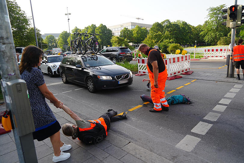 Passanten zerren die Aktivisten von der Straße.