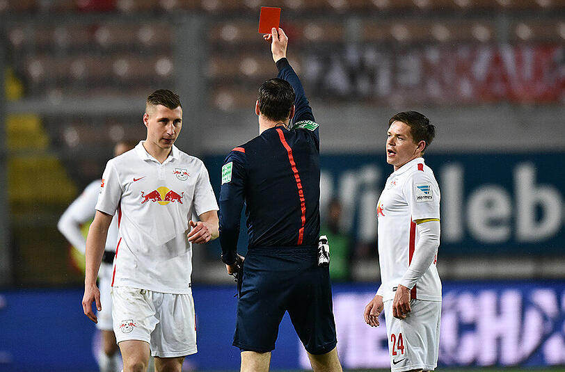 Schiedsrichter Bastian Dankert zeit Leipzigs Willi Orban (l.) die rote Karte.