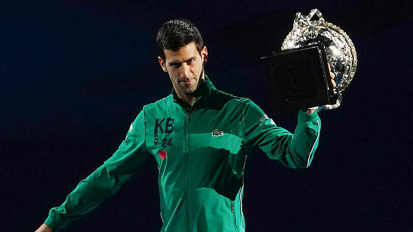 Novak Djokovic mit dem Siegerpokal der Australian Open - auf seiner Jacke sind die Initialen "KB" sowie die Nummern "8" und "24" zu erkennen