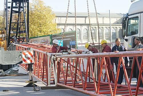 Bauarbeiter demontieren den Arm des havarierten Krans in seine Einzelteile.