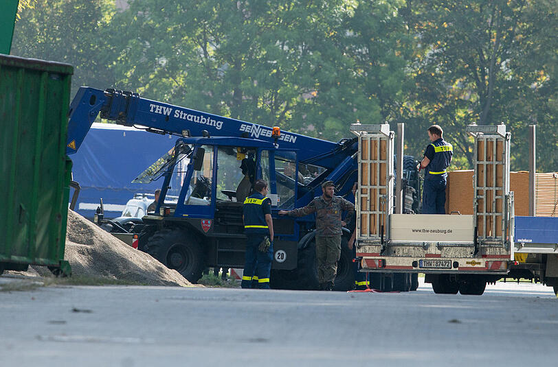Helfer vom Technischen Hilfswerk (THW) und Bundeswehrsoldaten bauen am Samstag auf dem Gelände der Gäubodenkaserne in Feldkirchen nahe Straubing (Bayern) Zelte auf.