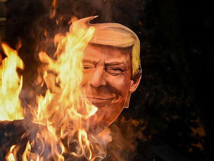 Eine Papp-Nachbildung des Kopfes von US-Präsident Trump wird während eines Protestes in Kalkutta verbrannt.