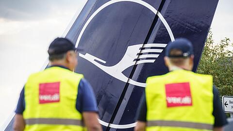 Zwei Verdi-Mitglieder stehen am Frankfurter Flughafen am Eingang zur Lufthansa-Basis.
