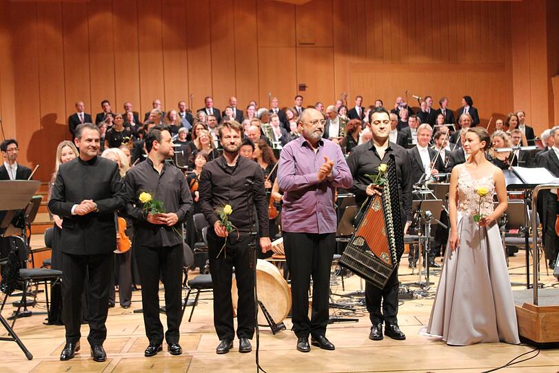 Das Pera-Ensemble (in Schwarz) mit Mehmet C. Yesilçay, dahinter die Münchner Symphoniker und der Domchor und sie Capella Cathedralis. Rechts: Sophie Pollak.