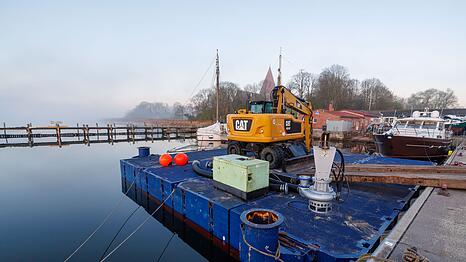 Auf der Arbeitsplattform steht unter anderem ein Bagger und ein Container.