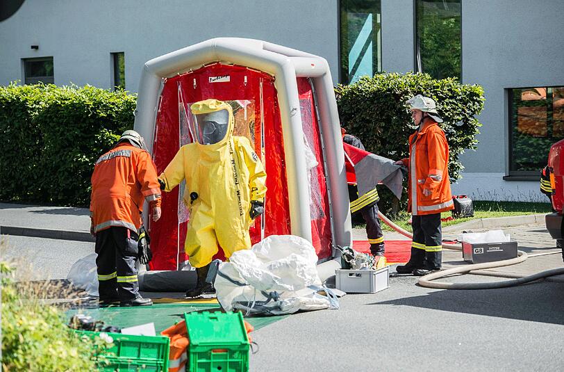 Mitglieder der Feuerwehr tragen am 11.07.2014 Schutzanzüge bei einem Einsatz nach einem Chlorgasaustritt in einem Schwimmbad in Glücksburg (Schleswig-Holstein). (Archivbild).