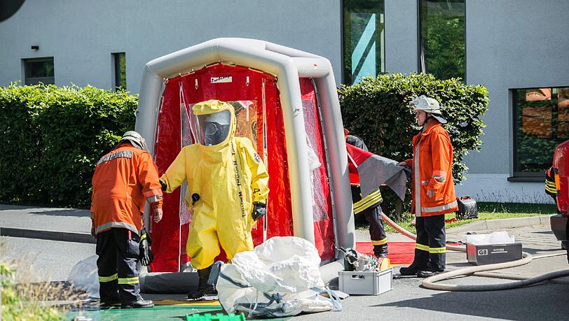 Mitglieder der Feuerwehr tragen am 11.07.2014 Schutzanzüge bei einem Einsatz nach einem Chlorgasaustritt in einem Schwimmbad in Glücksburg (Schleswig-Holstein). (Archivbild). Mitglieder der Feuerwehr tragen am 11.07.2014 Schutzanzüge bei einem Einsatz nach einem Chlorgasaustritt in einem Schwimmbad in Glücksburg (Schleswig-Holstein). (Archivbild).