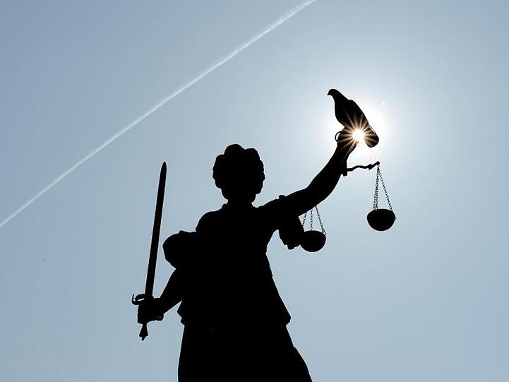Justitia mit Sonne und Taube. Foto: Arne Dedert/dpa/Symbolbild
