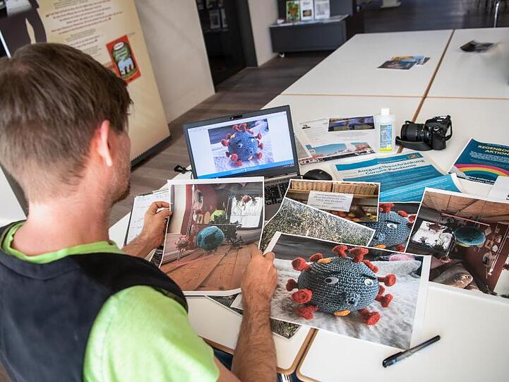 Der Leiter vom Museum Erding betrachtet ausgedruckte Bilder. Foto: Matthias Balk/dpa