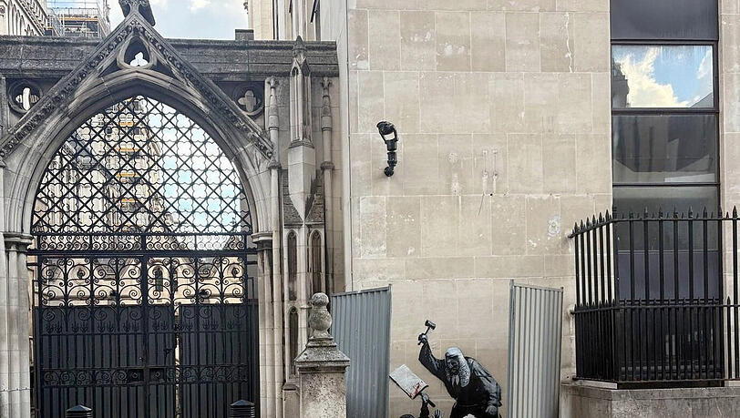 Ein neues Kunstwerk des Straßenkünstlers Banksy ist an der Fassade des Royal Courts of Justice zu sehen und zeigt einen Richter, der einen Demonstranten mit einem Hammer schlägt. Ein neues Kunstwerk des Straßenkünstlers Banksy ist an der Fassade des Royal Courts of Justice zu sehen und zeigt einen Richter, der einen Demonstranten mit einem Hammer schlägt.