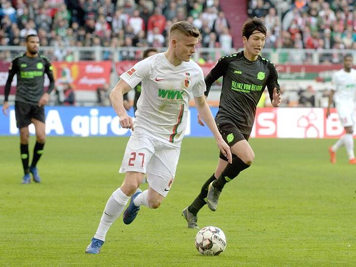 Augsburgs Alfred Finnbogason (l) im Laufduell mit Hannovers Genki Haraguchi.