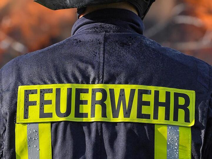 Ein Feuerwehrmann steht vor einer Rauchwolke. Foto: Patrick Pleul/ZB/dpa/Illustration
