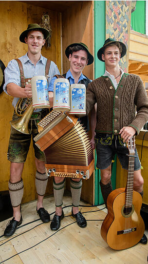 Die Musiker Sepp, Andreas und Quirin von der Band Eisbachmusi präsentieren im Armbrustschützenfestzelt den offiziellen Wiesn-Maßkrug zum Oktoberfest 2018.