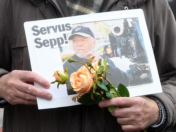 Ein Fan mit Blumen und einem letzten Gruß: "Servus Sepp!".