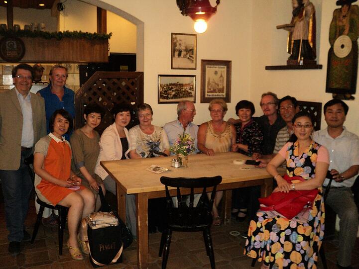 Shidong Zhen (sitzend, 3.v.l.), Ingeborg Staudenmeyer (sitzend, 6.v.l.), Wei Jia (sitzend, 7.v.l.) und Yawen Xuan (sitzend vorne, 2.v.r.); BA-Mitglieder: Wolfgang Schwirz und Marianne Kreibich (stehend, l.), Karin Angermeier (sitzend, 4.v.l.), Hans-Jörg Scheerer (sitzend, 5.v.l.) und Roland Zintl (sitzend, 8.v.l.).