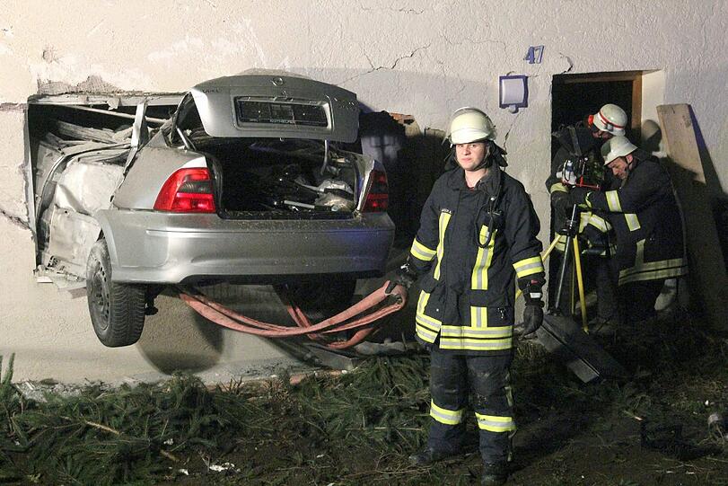 Rettunskräfte sind an der Unfallstelle in Ochsenhausen-Reinstetten (Baden-Württemberg) im Einsatz. Nach einem 15-Meter-Flug war ein Auto in ein Wohnzimmer gekracht.