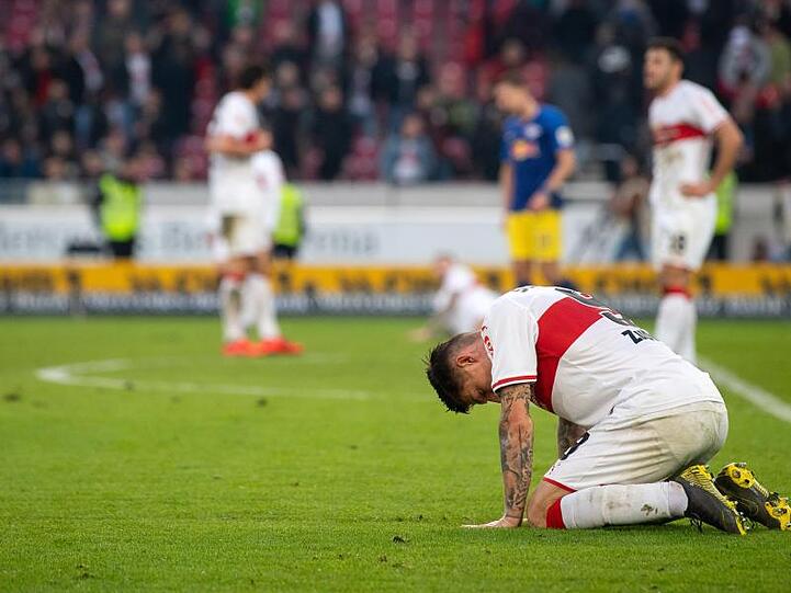 Stuttgarts Steven Zuber (r) kniet nach einer erneuten Niederlage enttäuscht auf dem Feld.