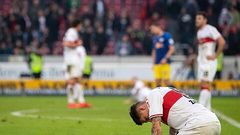 Stuttgarts Steven Zuber (r) kniet nach einer erneuten Niederlage enttäuscht auf dem Feld.