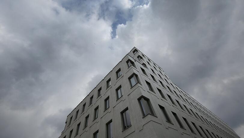 Nüchterner Ausblick: der Neubau des Regerhofs vor dunklen Wolken.